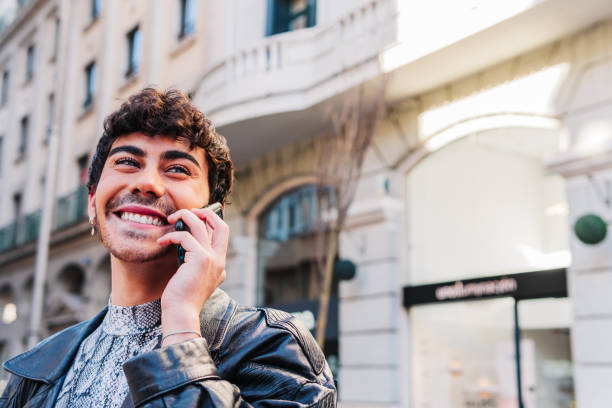 istock Smiling young Hispanic LGBT person talking on smartphone 1477558749