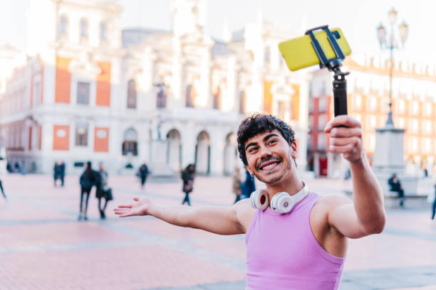 Cheerful Hispanic man taking selfie on smartphone