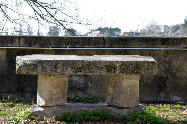 istock a bench made of stone in a garden. 1477561689
