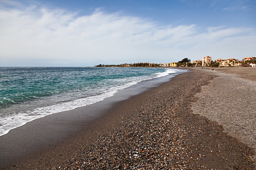 Spanish sea beach in the town of Motril with clear water and a small pebble beach.