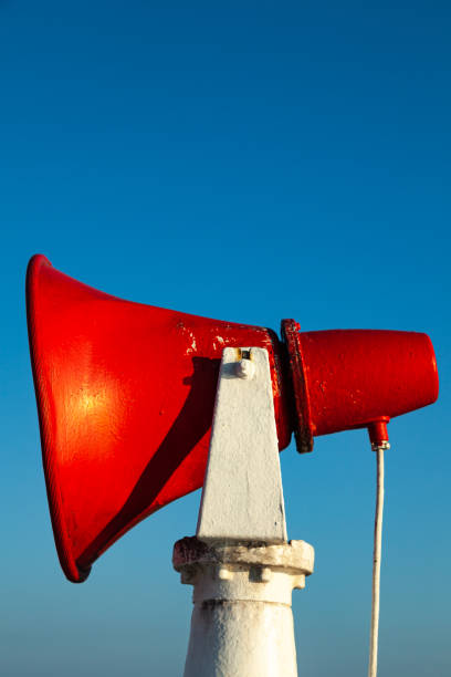 istock A red ship's horn is fixed on a steel rack against a blue sky. 1477562072