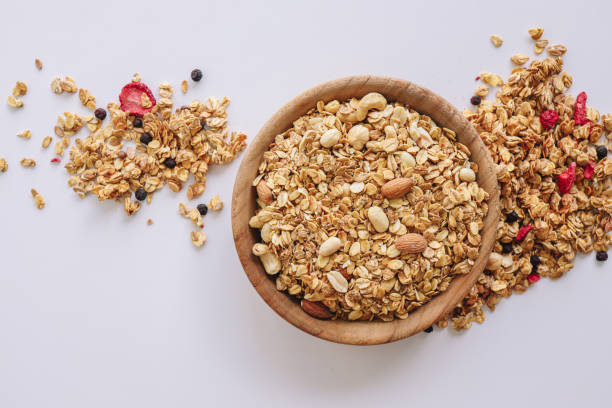 istock Granola with nuts and almonds on a white background, cereal scattered around 1477566342