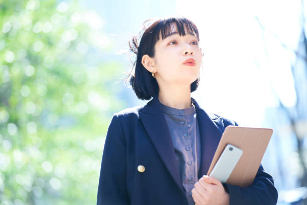 istock A woman looking up at the sky (business woman) 1477571345