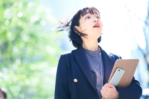 istock A woman looking up at the sky (business woman) 1477571370