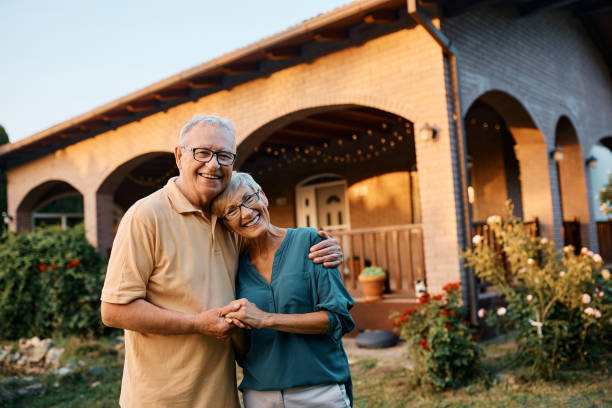 istock Embraced senior couple in the backyard looking at camera. 1477571427