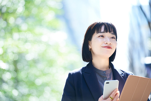 A woman holding a smartphone outdoors