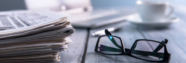 Newspapers with glasses and laptop. stock photo
