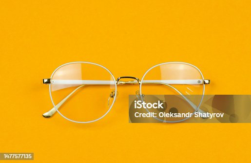 istock Stylish women's glasses in a white frame on a colored background. Stylish accessories. Glasses for vision 1477577135