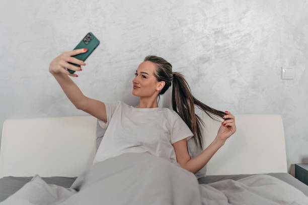 istock Young Woman Captures the Moment in Bed 1477578397
