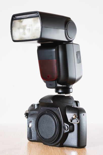 istock Photographic camera with handheld flash on top, on wooden table and white background, photography theme, left side view 1477580598