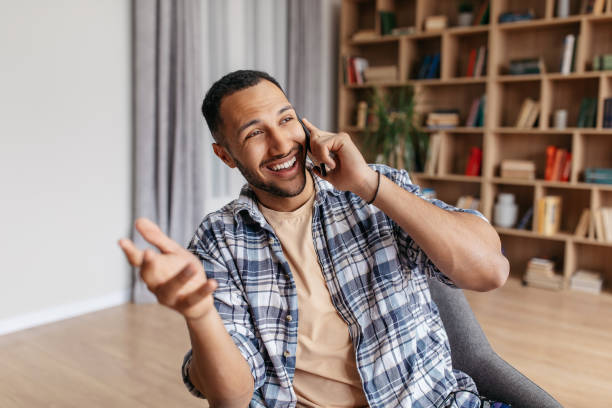 istock Excited middle eastern man talking emotionally on cellphone, sitting in chair at home, having phone conversation 1477580863