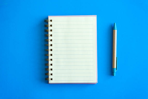 istock open notepad and craft pen next to it on a blue background. place for text. top view 1477581938