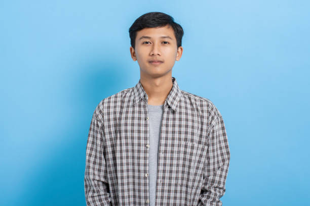 istock Young asian college student carrying books and backpack isolated over blue background 1477582186
