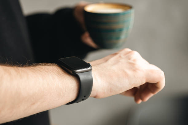 istock A man with coffee checking stylish smart watch, close up. 1477582275