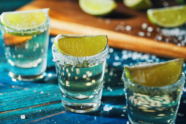 tequila shots avec sel et citron vert - tequila frappée photos et images de collection