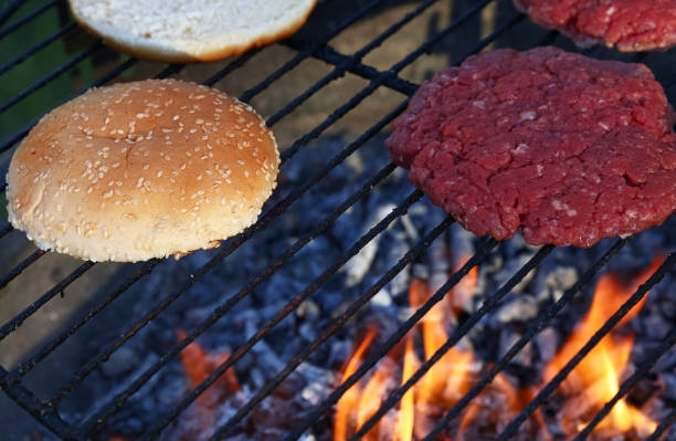 istock Meat burgers and buns for hamburger on fire grill 1477582794