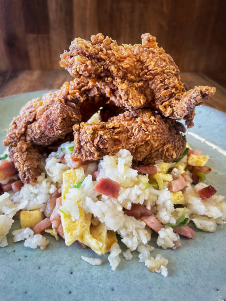 Kentucky hot wings with egg fry rice served on a light blue plate, wooden background Clouse Up.