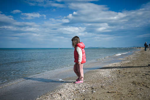 child looking at a sea water with surprise.