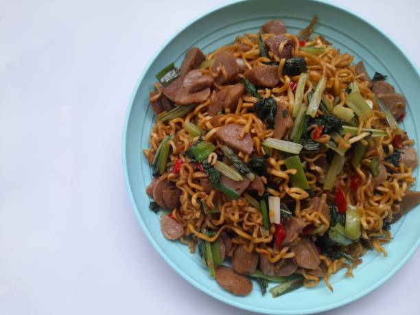 istock fried noodles with mixed mustard greens on a plate top view against a white background. 1477585140