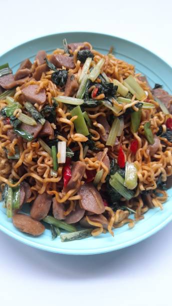 istock fried noodles with mixed mustard greens on a plate top view against a white background. 1477585195