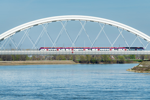 Novi Sad, Serbia - March 24, 2023: High-speed train Soko on Zezelj bridge over Danube bridge. This train travels between Belgrade and Novi Sad and can develop a speed of 200 km per hour