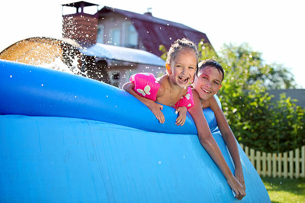 ragazzi che si diverte in piscina gonfiabile - above ground pool foto e immagini stock