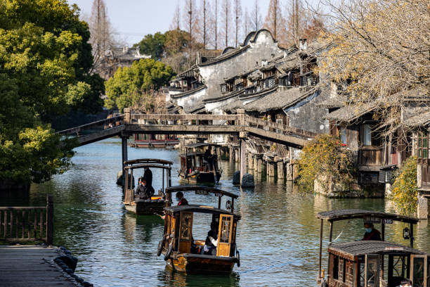 Jiaxing, China - Jan 10, 2023: River, boats, and buildings in the ancient Chinese village - Wuzhen.