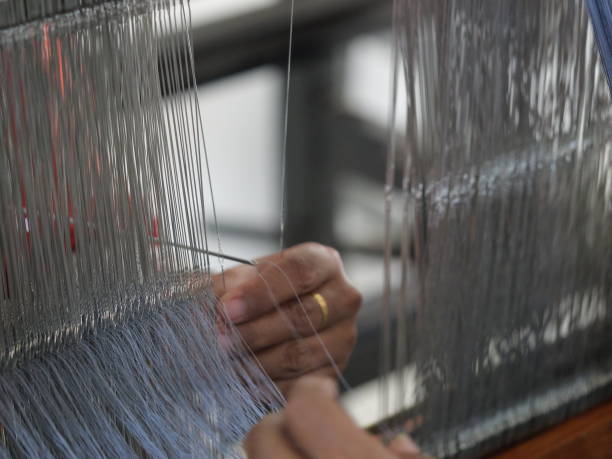 istock Selective focus traditional weaver is preparing yarn. Preparing the loom before starting to make woven ikat 1477589698