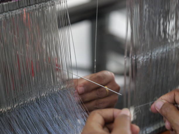 istock Selective focus traditional weaver is preparing yarn. Preparing the loom before starting to make woven ikat 1477589759