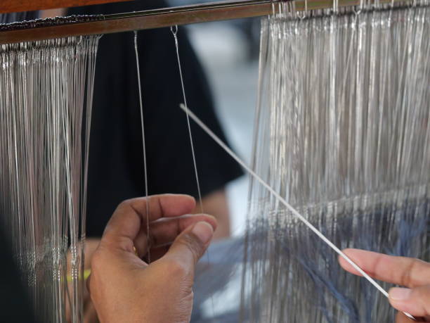 istock Selective focus traditional weaver is preparing yarn. Preparing the loom before starting to make woven ikat 1477591126