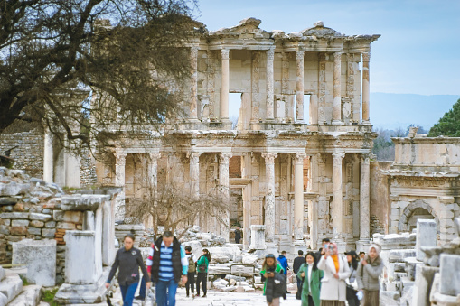 View of a people walking in front of the Library of Celsus. \nEphesus ancient city, Turkey.