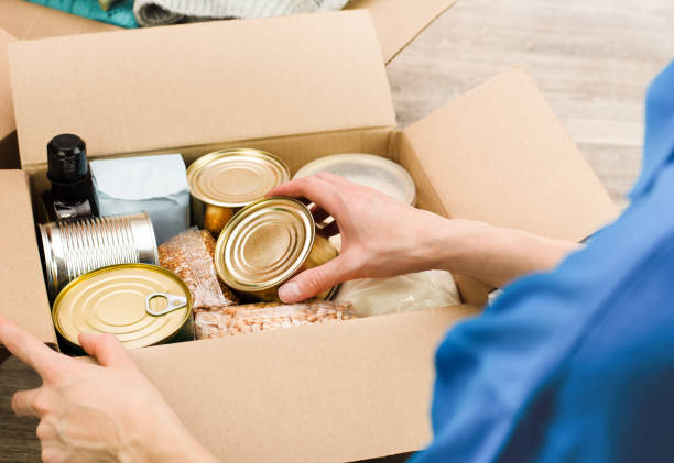 istock woman puts groceries in a cardboard box 1477603384