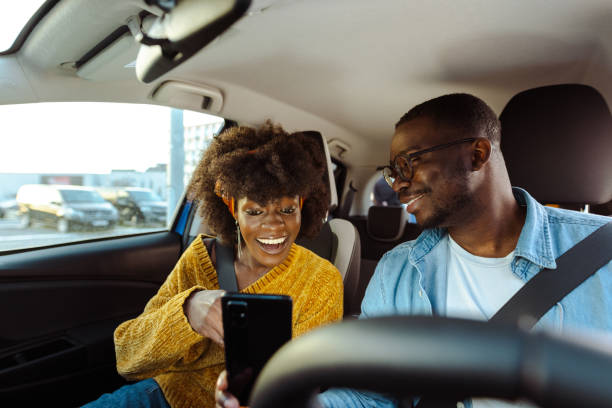 istock Cheerful African American couple using smart phone in car 1477609631