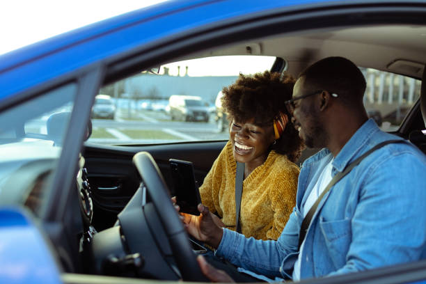 istock Cheerful African American couple using smart phone in car 1477611051