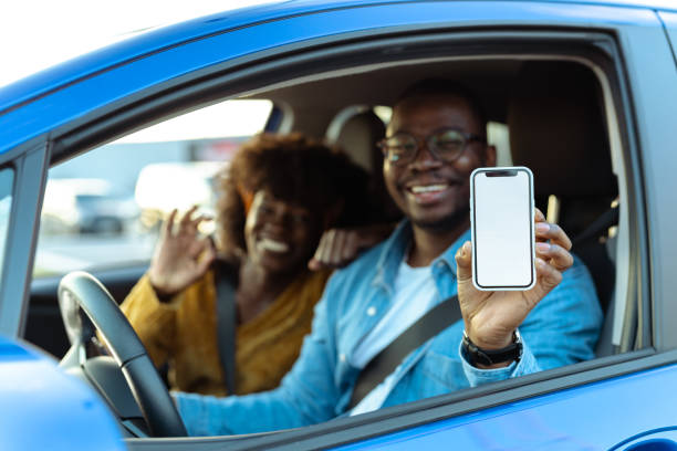istock African American couple showing smart phone with white screen while sitting in car 1477611088