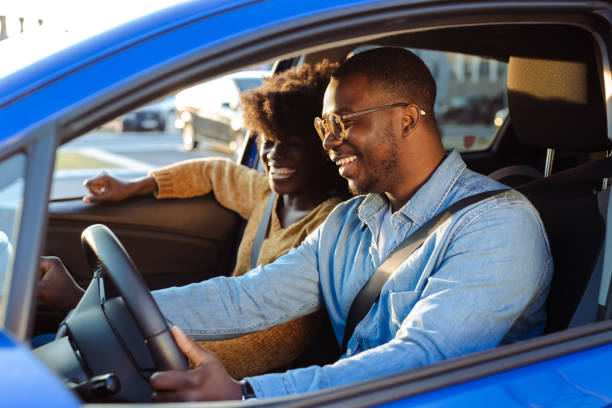 Cheerful African American couple in car stock photo
