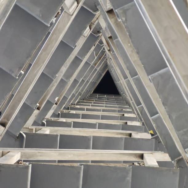 This photo was taken in a high-up position of a triangular rolling stairway. It captured the feeing when directly looking down to the darkness from above. Photo taken in Shenzhen, China in May 2022.