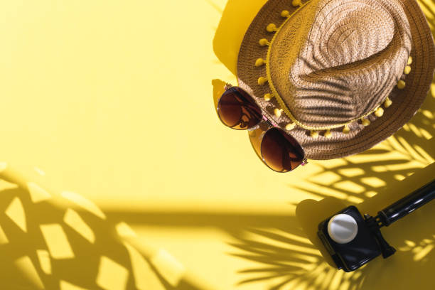istock Camera, straw hat and sunglasses on a yellow background. 1477614537