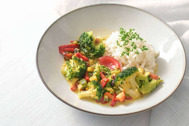 istock Vegetable dish from broccoli, leek and tomato served with rice and parsley garnish on a light gray plate, healthy vegetarian meal, copy space, selected focus 1477620268