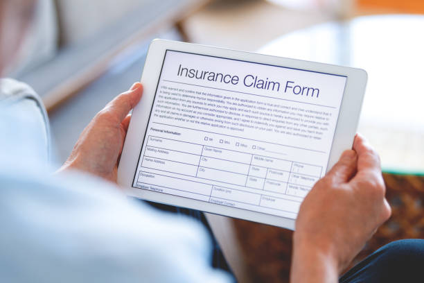 istock Man looking at an online insurance claim form on a digital tablet. 1477620627
