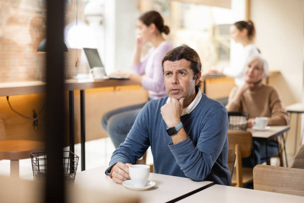 istock Thoughtful man drinking coffee at table in cozy cafe 1477622206