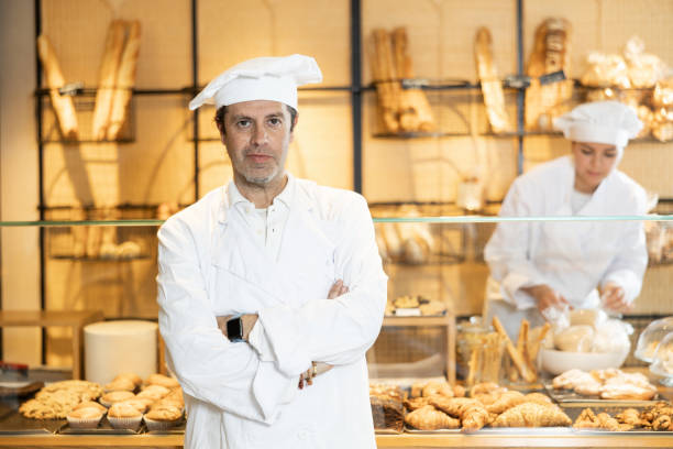 istock Confident baker in white uniform standign with arms crossed 1477623963