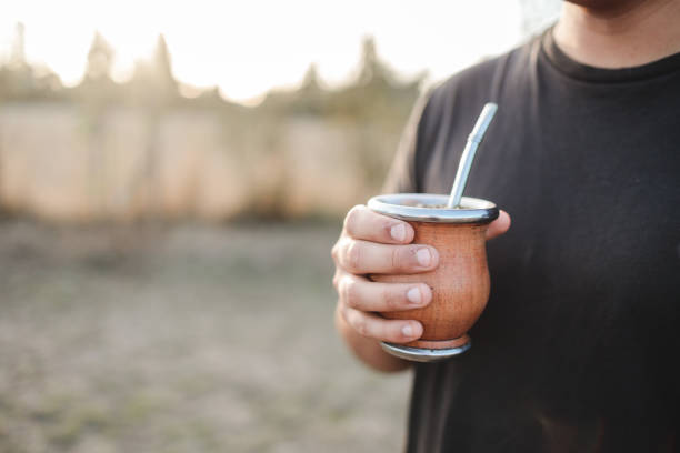 istock Unrecognizable young man holding yerba mate in the countryside at sunset. Copy space 1477625367