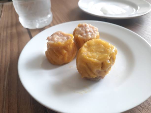 istock dimsum served warm on a white plate with sauce. 1477628919