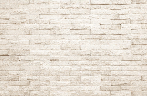 Background of wide cream brick wall texture. Beige old brown brick wall concrete or stone textured, wallpaper limestone abstract.