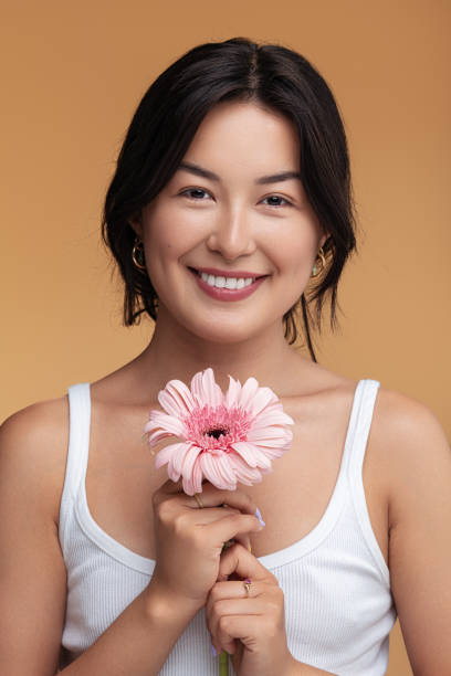 istock Optimistic Asian woman with gerbera flower 1477641445