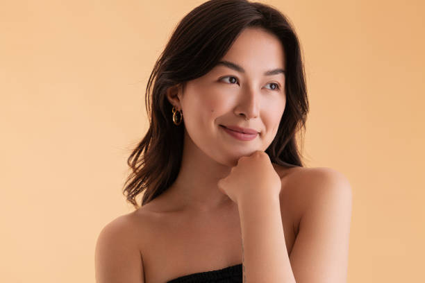 istock Graceful young ethnic female model smiling in beige studio 1477641492