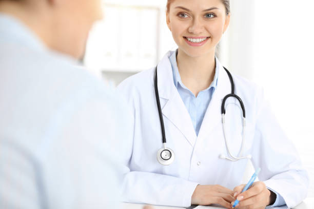 istock Friendly smiling doctor and patient sitting at the table 1477649581