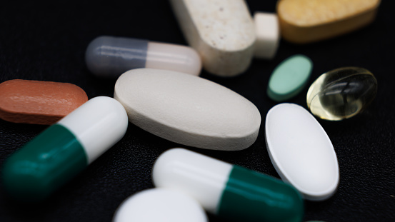 several different non-descript Rx prescription pills, vitamins and gel caps