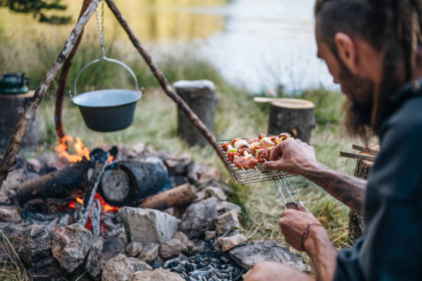 istock Man on camping cooking at the campfire. 1477652635